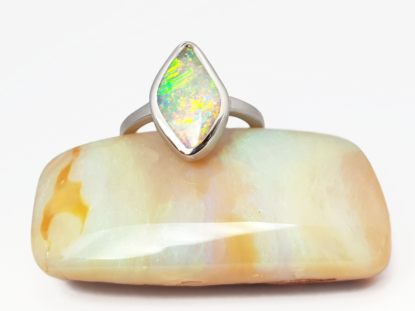 Luminescent Solid Crystal Pipe Queensland Opal. This ultra glittering opal is set in a smooth silver ring with a satin finish to offset the bright sparkly opal. Shining bright green, aqua, pink and orange sherbet flashes. The unique diamond shape sits low and smooth on your finger. Our products are all made with ethically sourced materials and handcrafted in our Brisbane based studio. Australian designed and Australian made for a high quality finish, fine fashion.