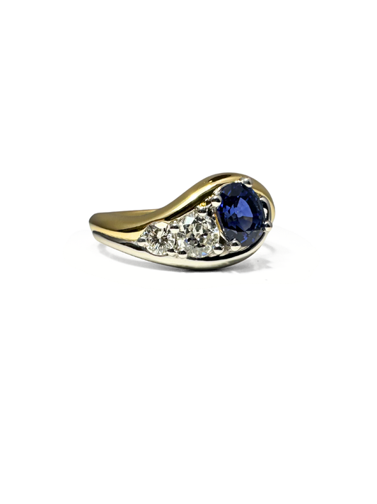 Custom Gold ring with a blue sapphire and smaller diamond on a white background