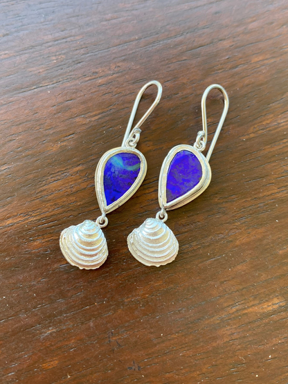 Pair of earrings with blue teardrop-shaped vivid blue opals and silver shell designs. Handmade design and ethically sourced gems. Made in Brisbane, Australia