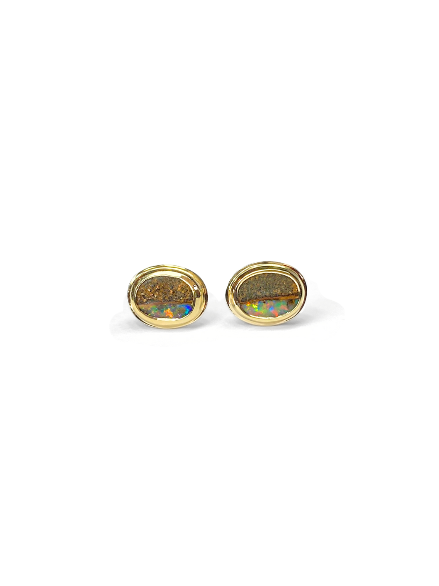 Pair of gold, bezel set earrings with opal stones on a white background. Opals include ironstone inclusions and a rainbow, glittery strip of opal