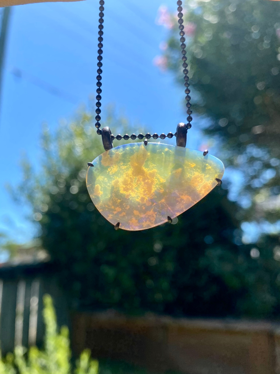 purple lightning ridge boulder opal pendant with blackened silver Glasshouse Mountains against light