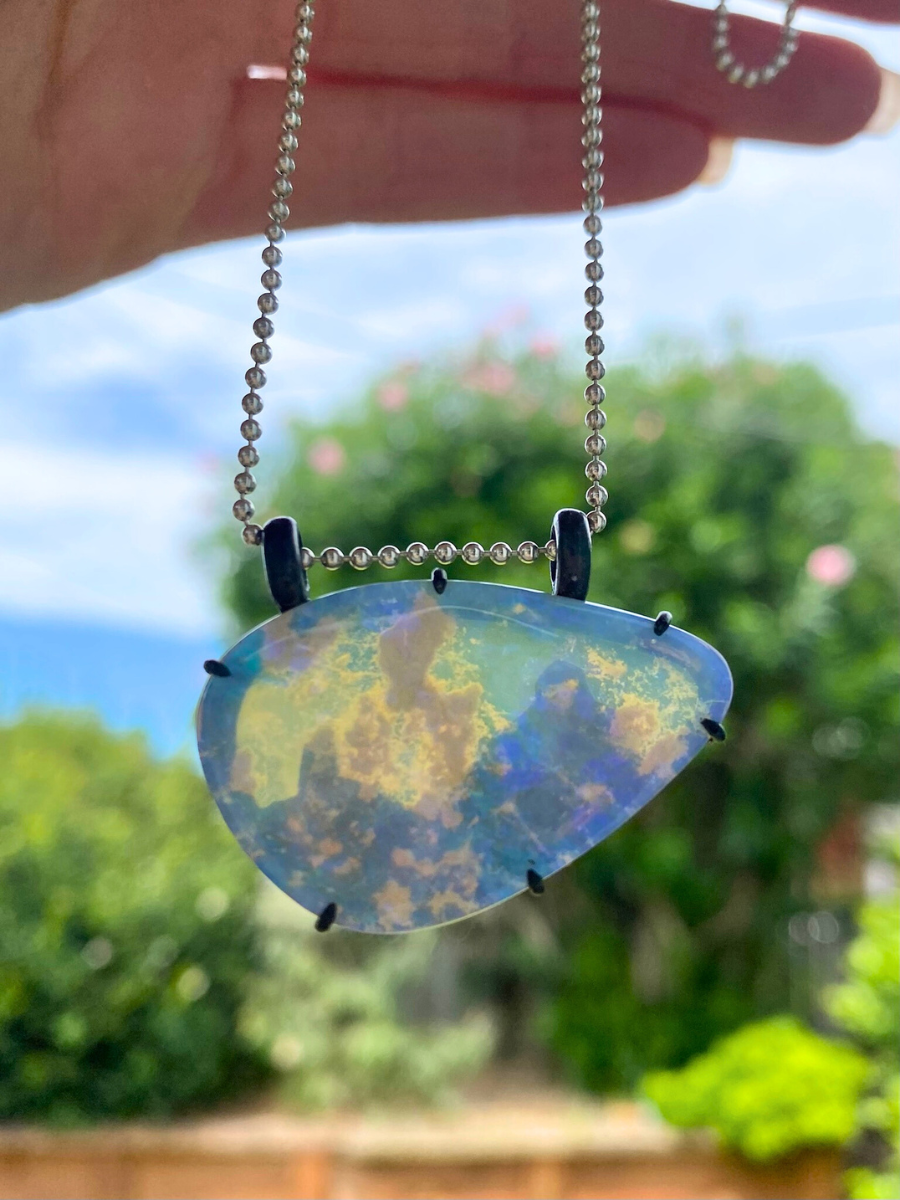 purple lightning ridge boulder opal with blackened silver Glasshouse Mountains against the light