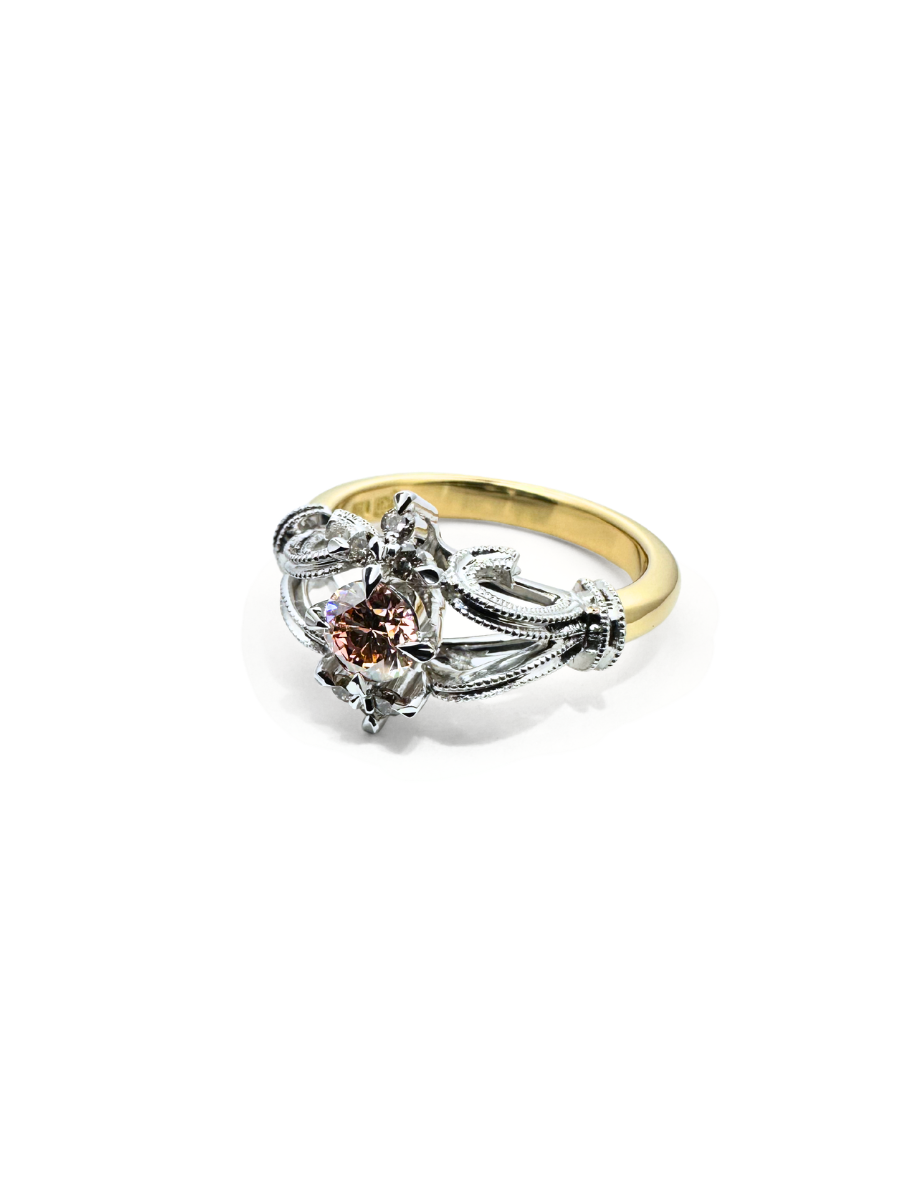 Gold and silver vintage ring design with a central gemstone on a white background
