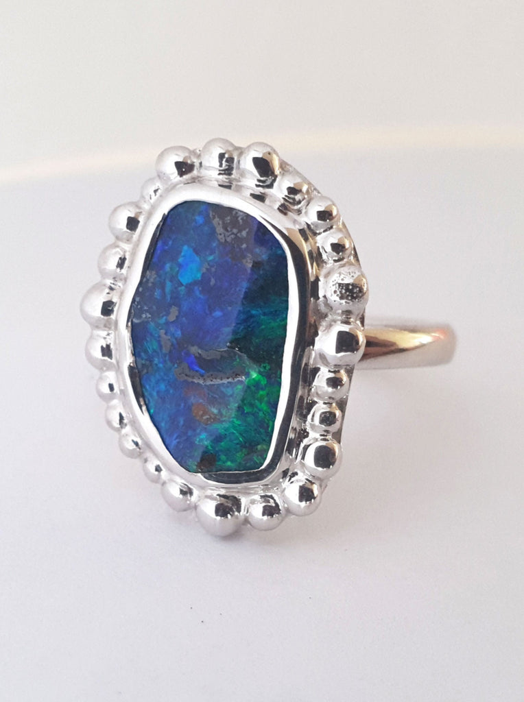 Silver ring with blue and green coloured opal. Silver balls frame the opal for a unique high fashion look. Handcrafted using ethically sourced materials in our Brisbane studio.