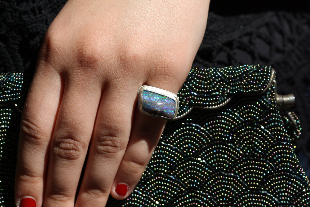 Photo on han. Australian made and handcrafted in our Brisbane, ethical jewellery made from local products. Silver ring with a textured setting and a blue and green qld boulder opal.