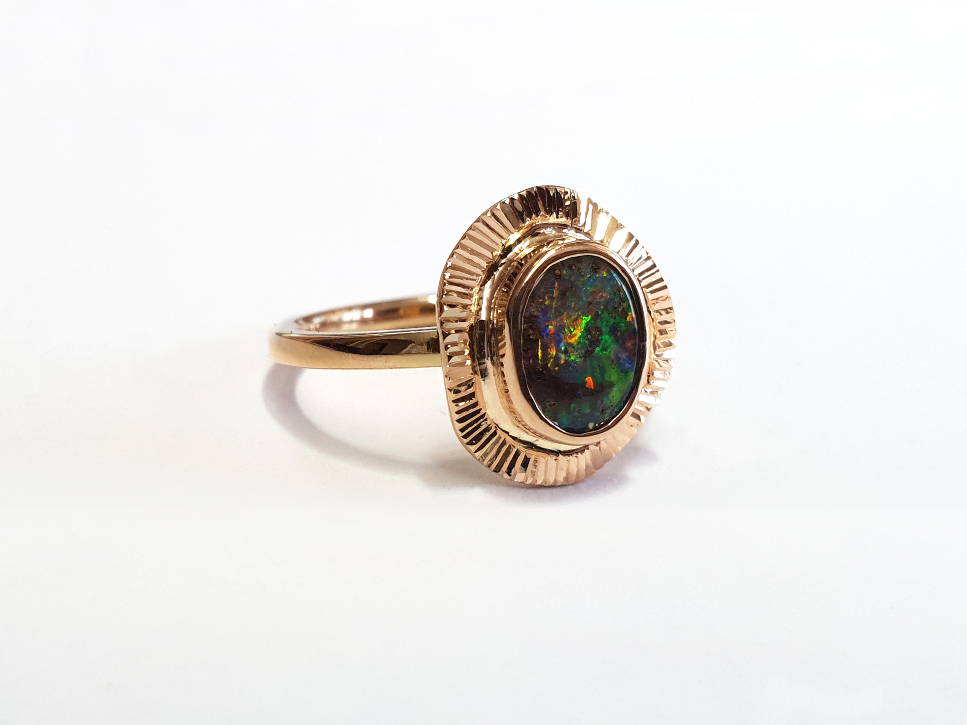 Green, Blue and Red Queensland Boulder Opal set in 9ct Rose Gold ring. Rose gold fans out around the stunning opal creating a unique and high quality ring. Australian made, and hand crafted for a unique style. Our products are all made with ethically sourced materials and handcrafted in our Brisbane studio