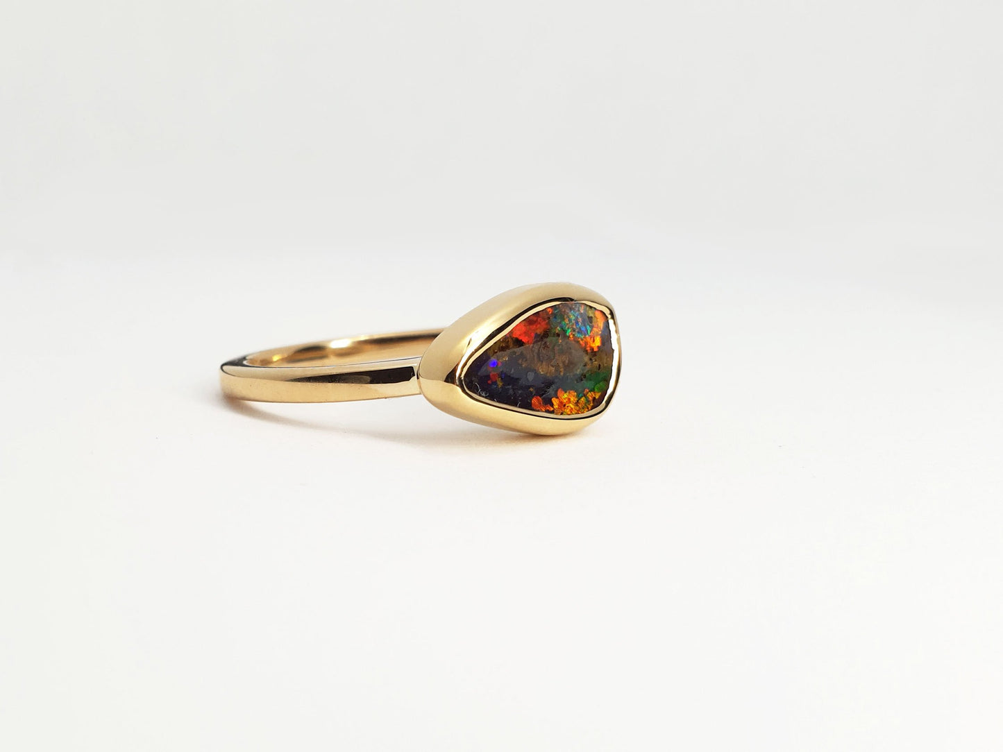 18ct yellow gold polished gold ring with Queensland boulder opal. Opal flashes red, blue, green and purple. Australian designed and Australian made for a high quality finish. Ethical and fine fashion by Custom Jewellery Co by using ethically sourced local products and handcrafted in our Coastal Queensland Studio