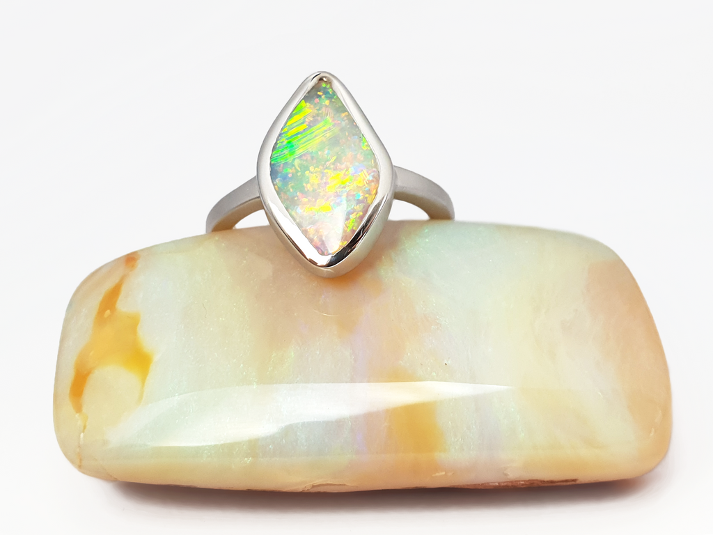 Luminescent Solid Crystal Pipe Queensland Opal. This ultra glittering opal is set in a smooth silver ring with a satin finish to offset the bright sparkly opal. Shining bright green, aqua, pink and orange sherbet flashes. The unique diamond shape sits low and smooth on your finger. Our products are all made with ethically sourced materials and handcrafted in our Brisbane based studio. Australian designed and Australian made for a high quality finish, fine fashion. 