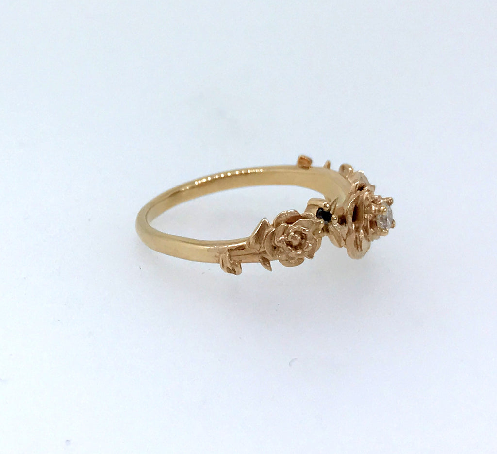 Rose gold ring with white diamonds and black diamonds. Set in an original design of rose and thorns. This ring is handcrafted using ethically sourced materials